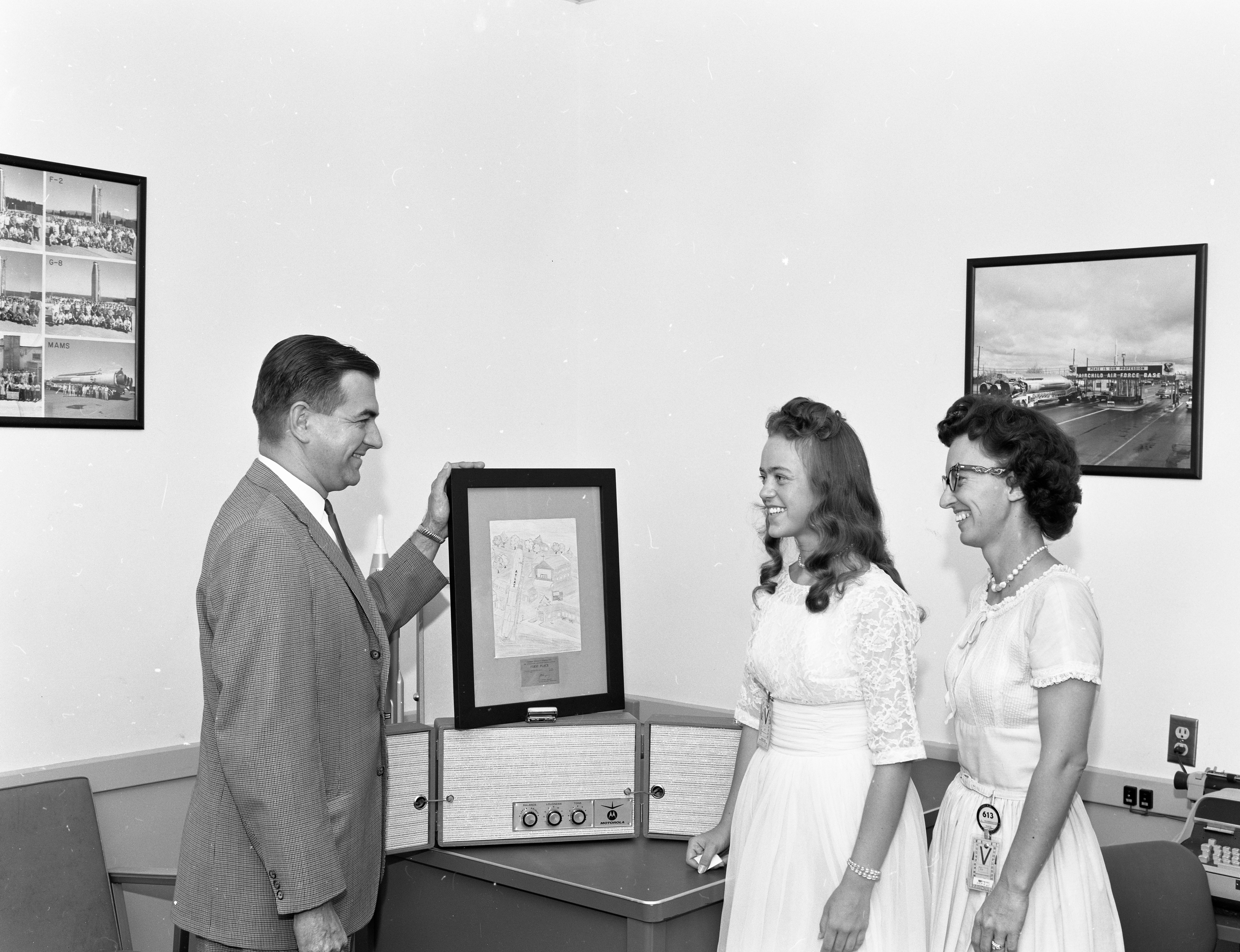 Chana presenting a stereo record player to Gloria Niederhauser and her daughter on August 14th, 1961. 